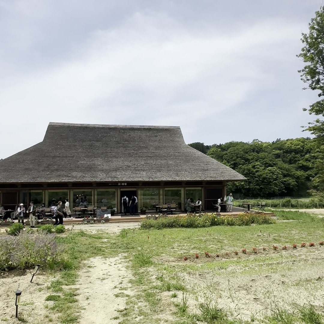 陽・燦々 外観 アプローチ 駐車場から歩いて見える茅葺きレストラン 淡路島