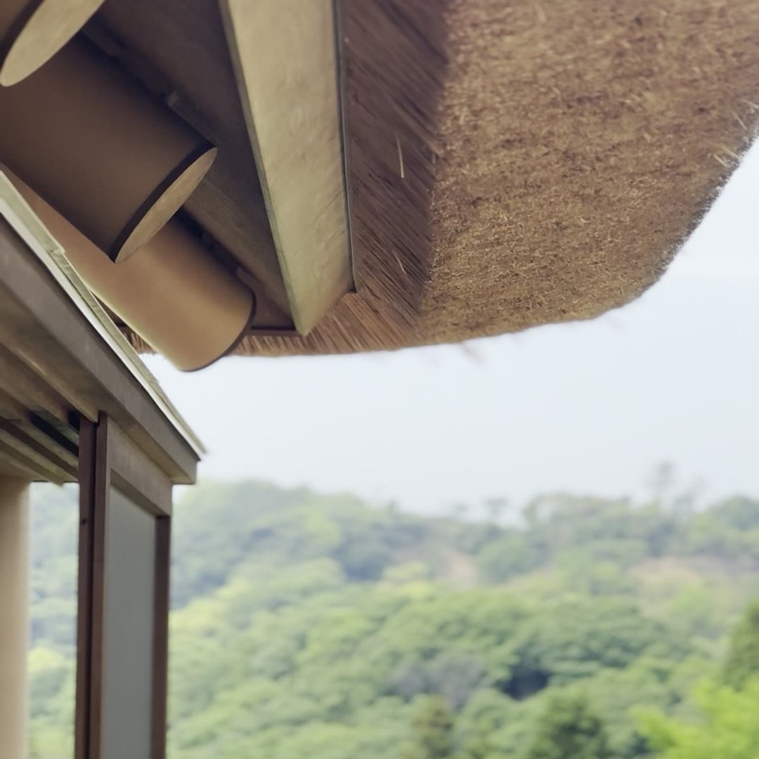 陽・燦々 茅葺き屋根の軒先 テラス側からの眺め 淡路島の山並み